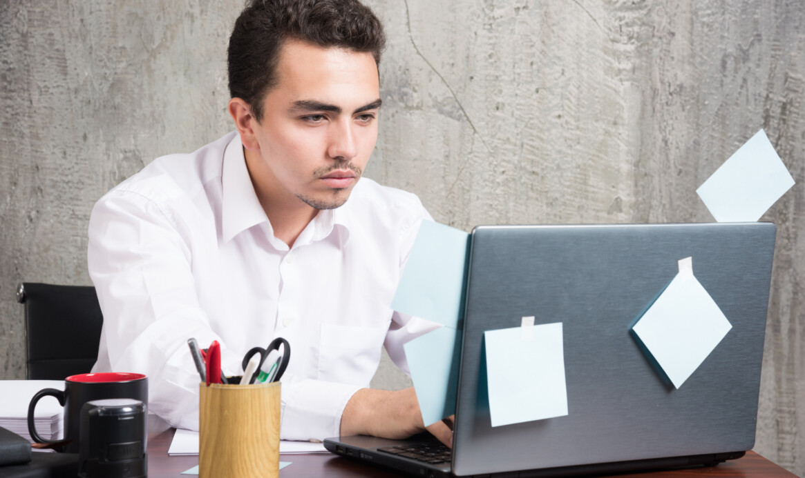 Businessman playing with laptop at the office desk