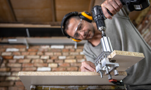 The carpenter works as a professional tool for drilling wood.
